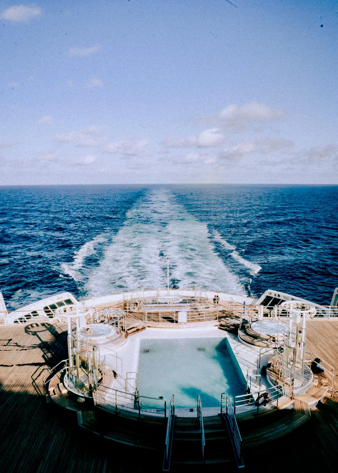 The pool deck at the stern, the ship's wake drawing a straight line across the Atlantic to the horizon