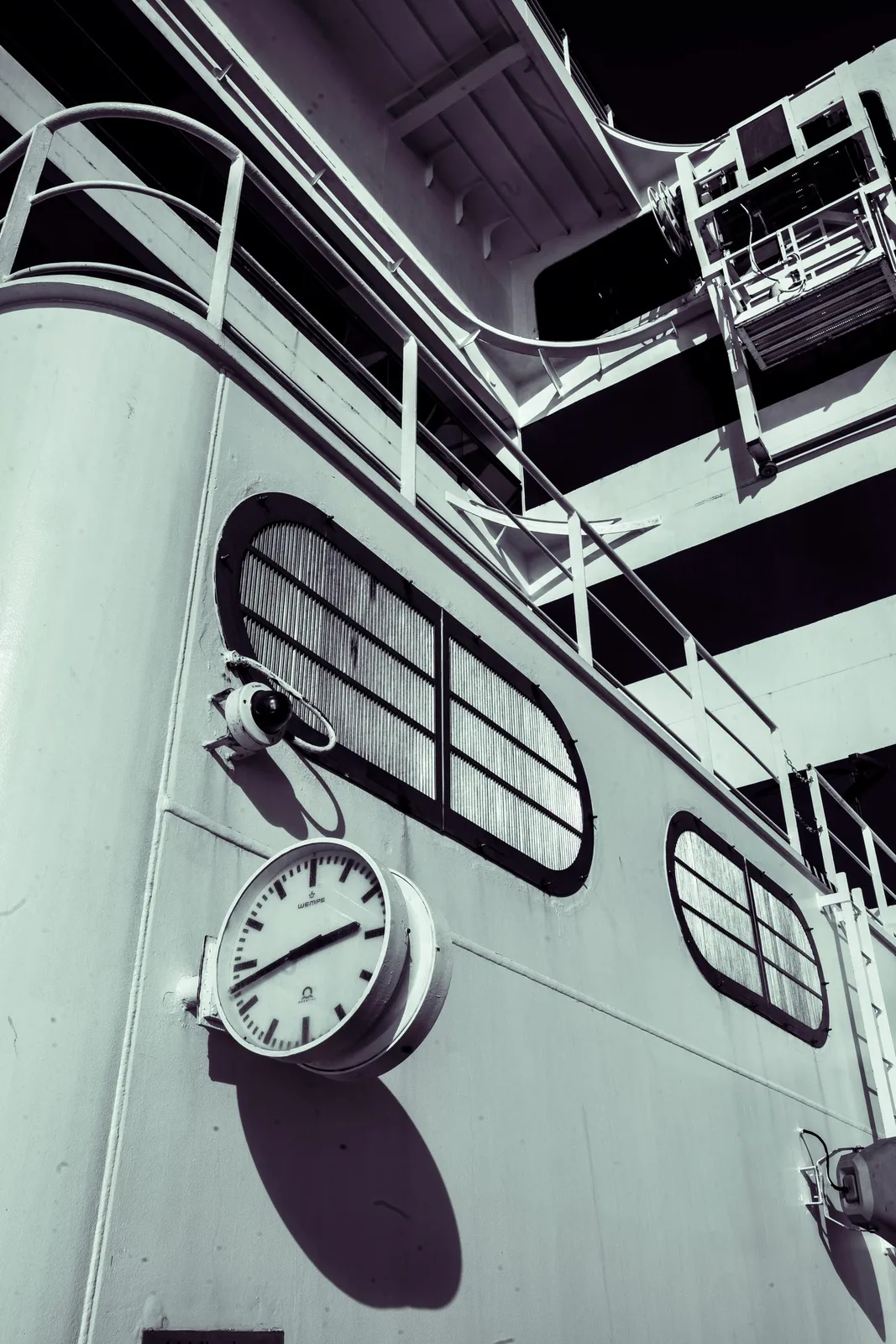 Black-and-white detail of the ship's white superstructure with a round Wempe deck clock